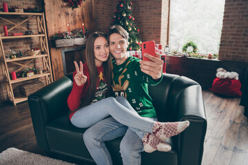 Canvas Print - Photo portrait young guy in ugly sweater taking selfie with girlfriend showing v-sign on couch