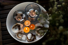 Bowl Of Burning Candles And Pebbles With Seashells