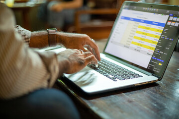 Asian businessmen working and data analysis with computer labtop at coffee shop