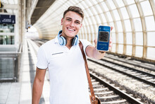 Happy Man Showing Vaccination Qr Code On Smart Phone Screen At Subway Platform