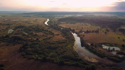 Poster - Calm river in the morning with a rising sun on the background. 4K drone video of beautiful river