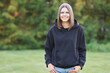 © Kalim - Young woman in black hoodie.