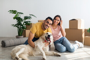 Wall Mural - Full length portrait of happy young diverse couple with their dog posing on floor of new home on moving day