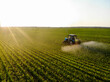 © zorgens - Tractor sprays pesticides on corn fields at sunset