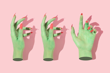 Halloween creative pattern with green witch hands with bright pink nails against pastel pink background. Aesthetic holiday idea. Minimal flat lay concept.