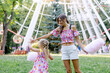 © Hanna Chayka - woman with a child walks in nature in sunny weather against the background of an attraction