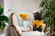 Cute caucasian child girl and a black poodle dog in a cozy yellow knitted hat and a dog sweater. Concept cozy winter and christmas, pets and children at home