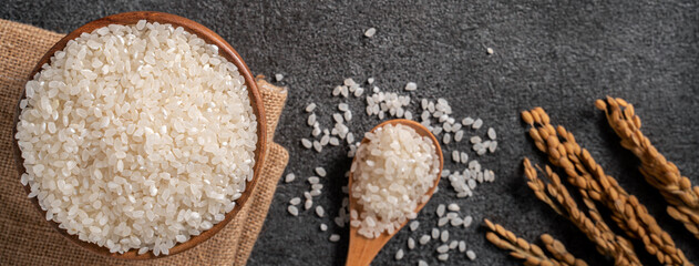 Wall Mural - White rice in a bowl on dark black table background.