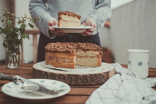 Woman Serving A Slice Of Sponge Crumble Cake