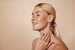 © Artem Varnitsin - Side view of smiling woman with freckles standing with closed eyes touching her neck