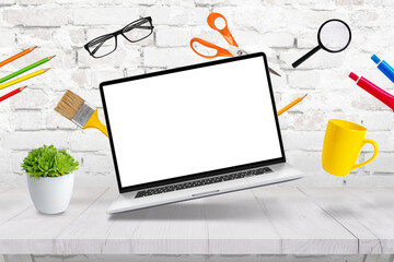 Wall Mural - Laptop mockup levitating with creative  office supplies above the desk concept