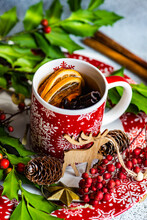 Cup Of Spiced Mulled Tea On A Table With Holly And Spices