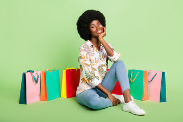 Poster - Full length photo of young black girl happy positive smile dream sale shop sit floor isolated over green color background