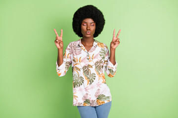 Poster - Photo of young afro girl pouted lips send air kiss flirty show peace cool v-sign isolated over green color background