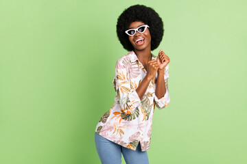 Wall Mural - Photo of young african woman happy positive smile have fun dance wear sunglass isolated over green color background