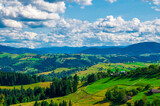 Fototapeta Krajobraz - pastures of young green grass on the slopes of the mountains against the backdrop of a beautiful blue sky. High quality photo