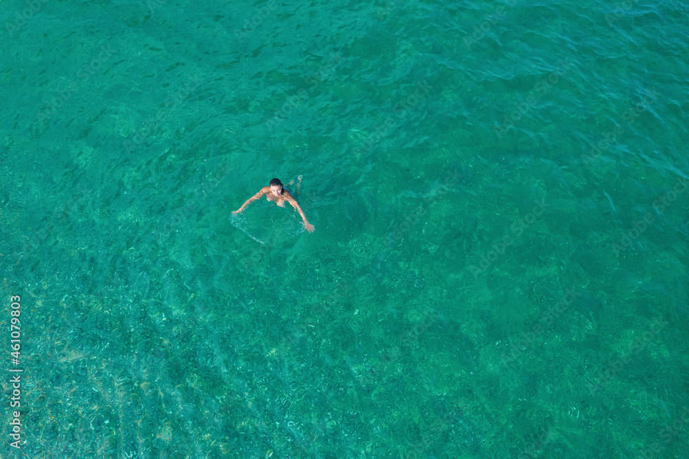 Young nude beautiful, sexy woman with naked breast taking off swimsuit