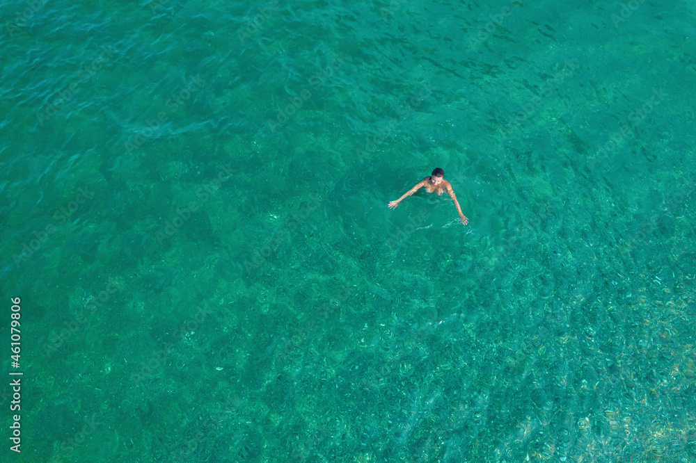 Young nude beautiful, sexy woman with naked breast taking off swimsuit