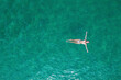 © flowertiare - Young nude beautiful, sexy woman with naked breast lying on sea, ocean water. Summer. View from above. Top view, copter