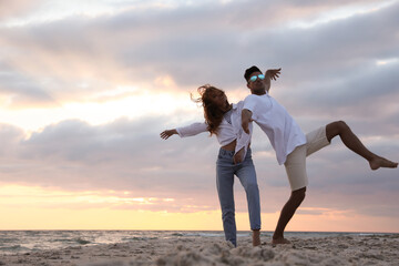 Sticker - Happy couple dancing on beach at sunset