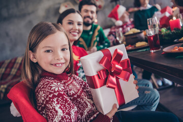 Wall Mural - Photo of happy little girl husband wife family hold hand gift box xmas dinner christmas indoors inside house home