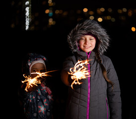 Wall Mural - Children with Bengal lights outdoors at night in winter