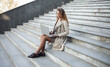 © splitov27 - Young woman student using laptop while sitting on stairs outdoors