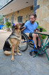 © Ekaitz - Happy young man in wheelchair with his dog in the backyard of his home