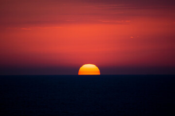 Wall Mural - Red disk of the sun. Sea sunset.