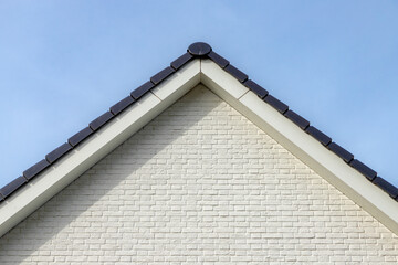 Structure and building concept, The side of building white brick wall under blue sky as background, Architecture features traditional houses with gable roof in europe.