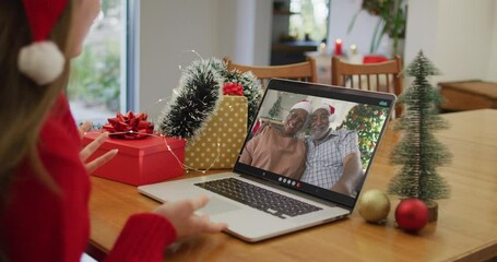 Sticker - Caucasian woman wearing santa hat having a videocall on laptop at home during christmas