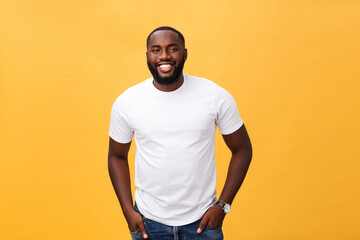 Portrait of delighted African American male with positive smile, white perfect teeth, looks happily at camera, being successful enterpreneur, wears white t shirt.