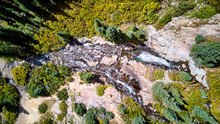 Aerial View Looking Down At Twin Waterfalls In The Rocks With Scattered Trees