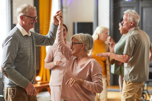 Fototapete Group of smiling senior people dancing while enjoying activities in retirement home, copy space