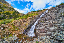 Waterfall Over Slopped Spiky Rocks In The Colorful Fall Mountains