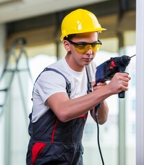 Wall Mural - Man drilling the wall with drill perforator