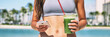 Green smoothie juice cleanse online phone app fitness diet plan banner panoramic. Woman stomach closeup with hands holding cup and mobile cellphone for takeout delivery. Vacation girl drinking detox.