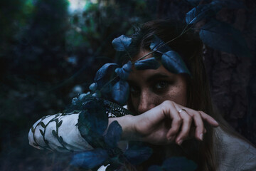 Wall Mural - girl in a historical dress in a coniferous forest