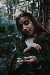 girl in a historical dress in a coniferous forest