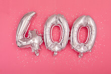 From Above Of Silver Shiny Balloons Demonstrating Number 400 Four Hundred Pink Background With Scattered Glitter