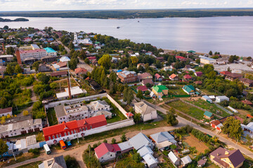 Wall Mural - General aerial view of Kozmodemyansk townscape on banks of Volga River on sunny summer day, Mari El Republic, Russia