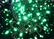 Rolled up Christmas garland with green glowing bulbs 