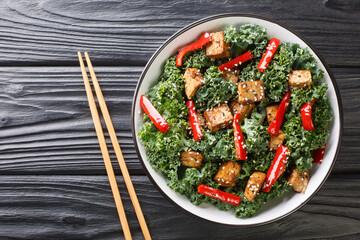 Wall Mural - Asian vegetarian teriyaki tofu salad with peppers, kale and sesame seeds close-up in a bowl on the table. horizontal top view from above