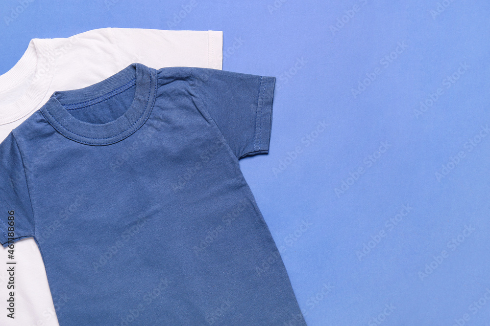 Stylish t-shirts on blue background, closeup