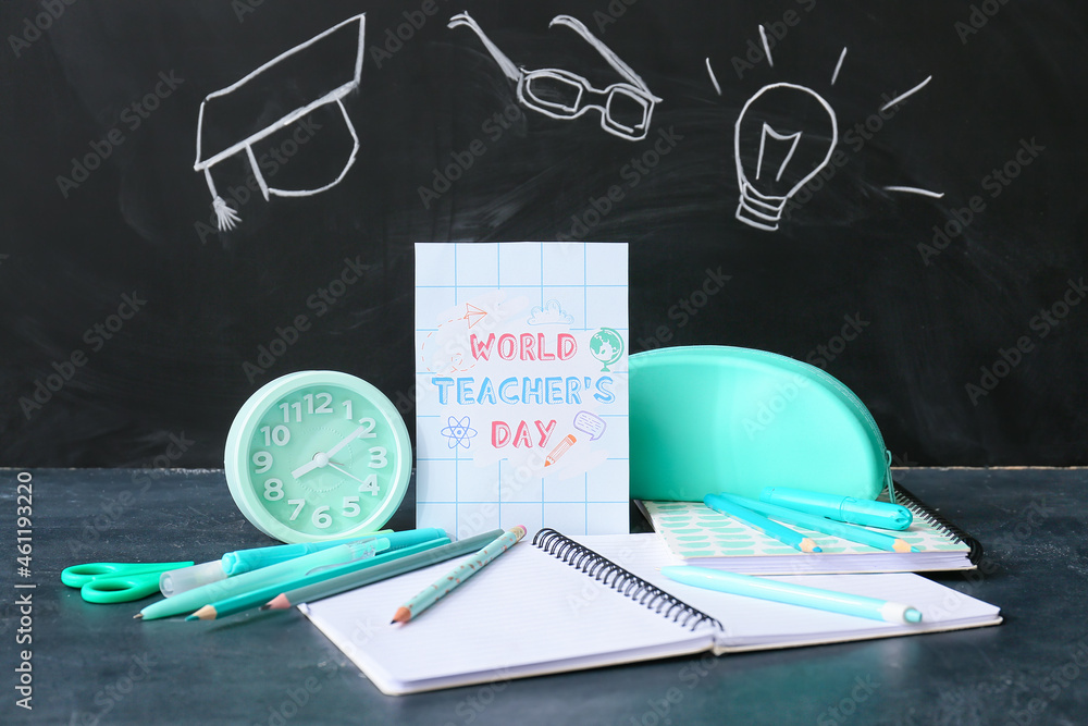 Greeting card for Teacher's Day, alarm clock and stationery on table in classroom