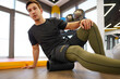 © fotofabrika - The man is massaging his leg muscles with the foam roller