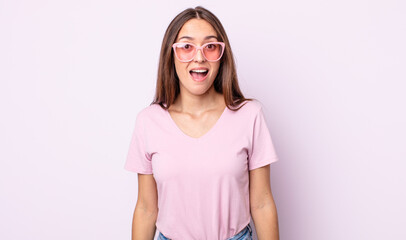 Wall Mural - young pretty woman looking happy and pleasantly surprised. pink sunglasses concept