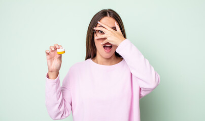 Poster - young pretty woman looking shocked, scared or terrified, covering face with hand. contact lenses concept