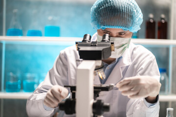 Wall Mural - scientist looking through scientific microscope lense in laboratory, scientist doing research in ter
