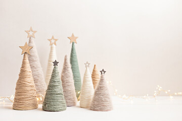 Wall Mural - Christmas craft background with handmade yarn cone xmas trees in natural colors.  DIY organic sustainable christmas decoration